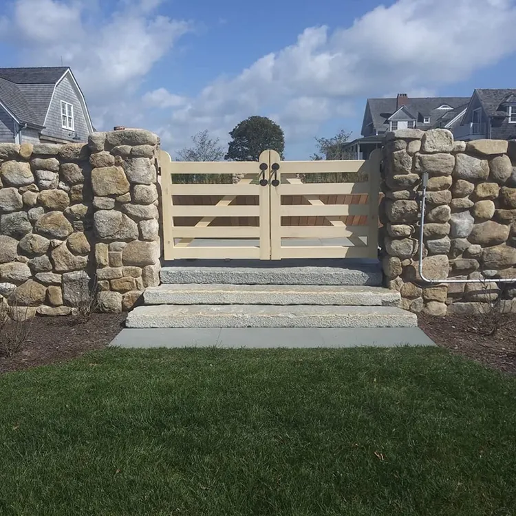 a stone fence with a wood gate